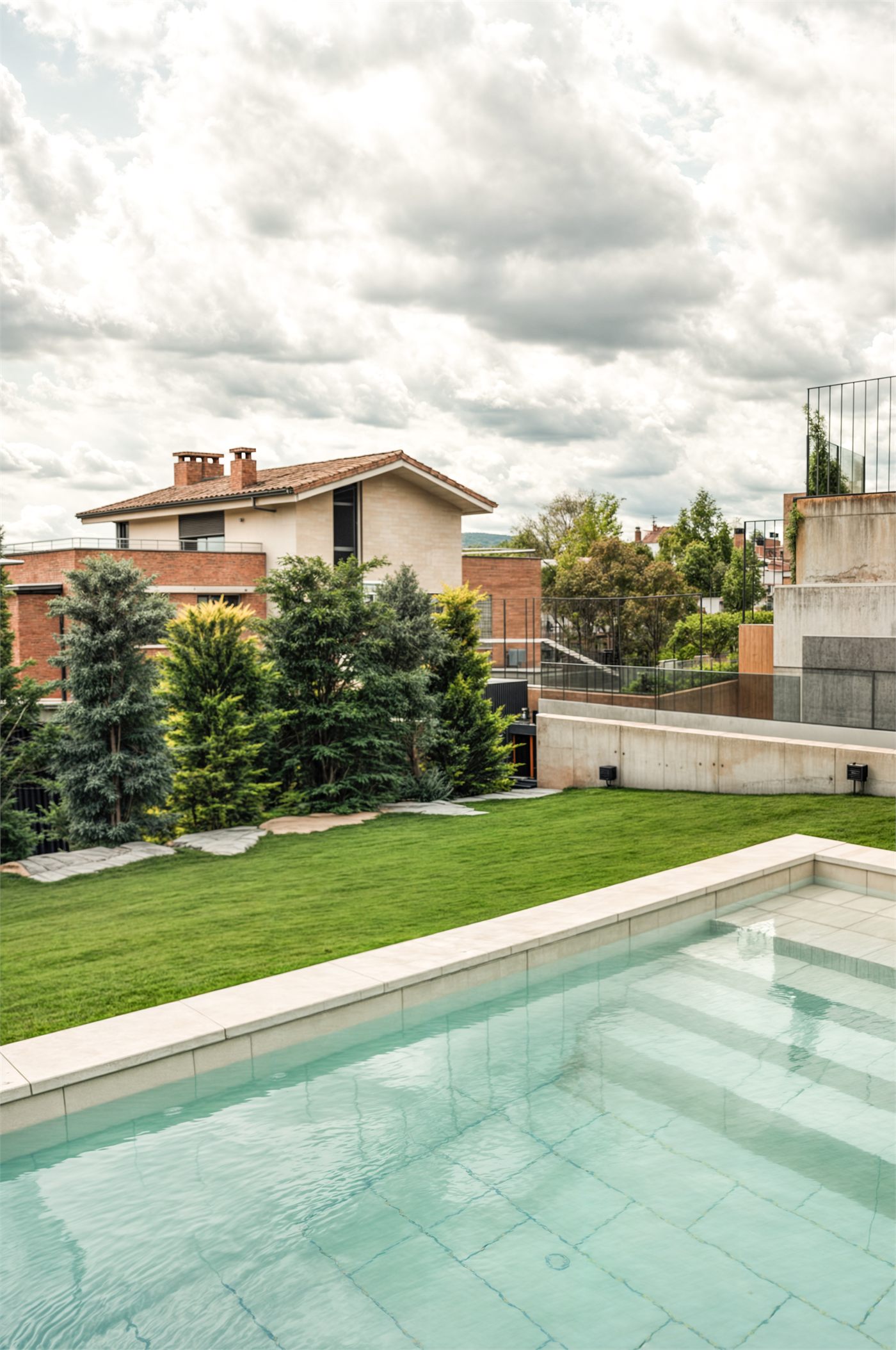 Piscina rectangular amb la gespa i la pantalla vegetal perimetral