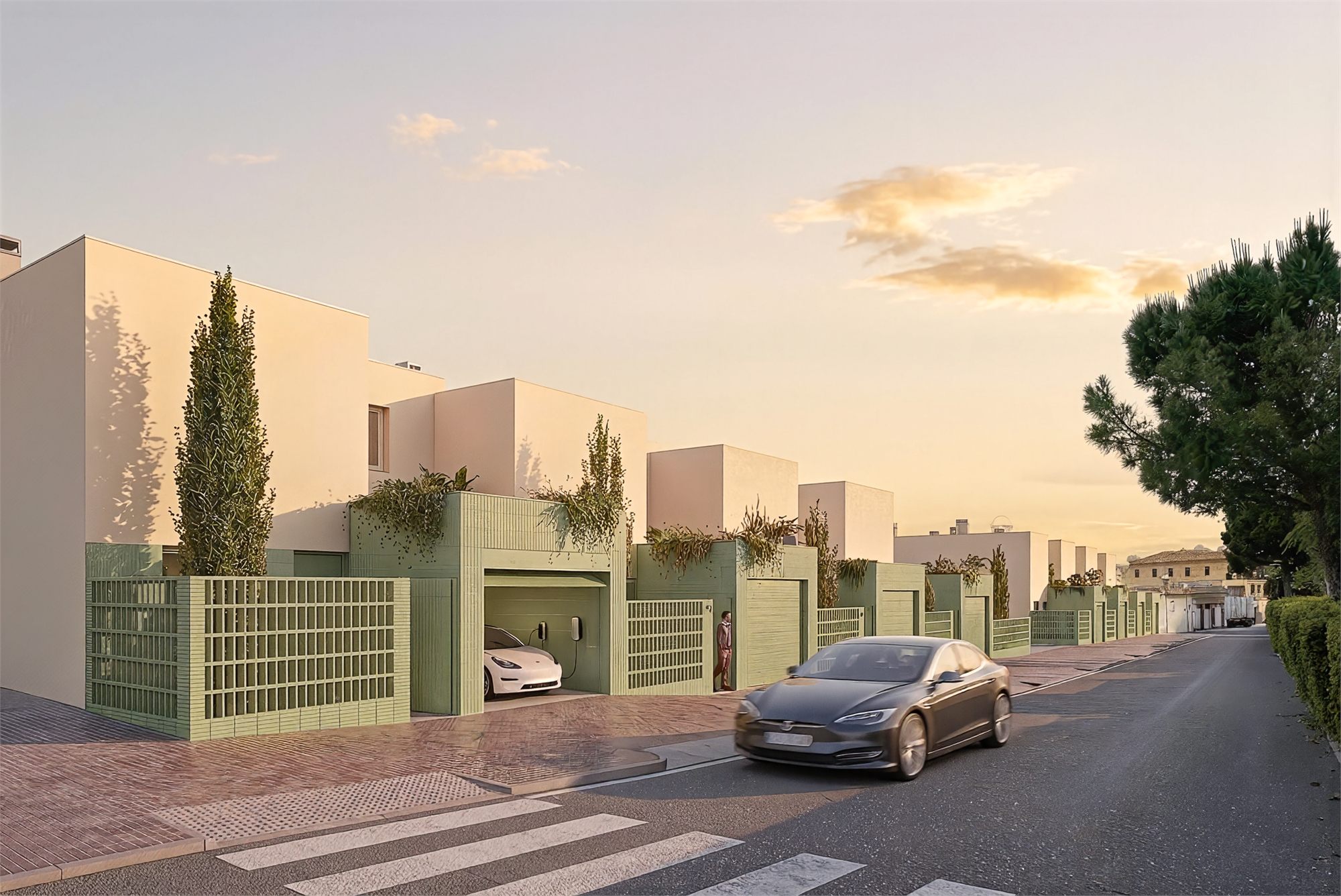 La filada vista des del Camí de la Fàbrica Nova a última hora de la tarda: les tanques de rajola verda amb les gelosies, els garatges oberts i el carrer que baixa cap al fons de l'àmbit